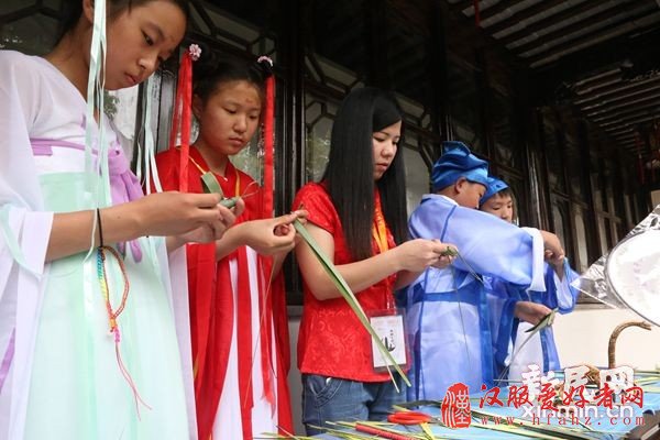 图说：身着汉服体验包粽子。 于俊丽/摄