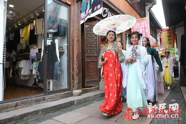 图说：女孩子身着汉服穿梭在老街匾额旗招。 于俊丽/摄