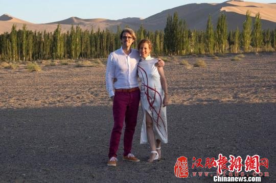 图为新郎新娘在敦煌鸣沙山下合影留念。　王斌银　摄