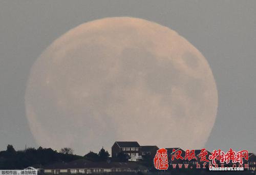 资料图：当地时间2015年9月27日，英国南部城市布莱顿，一轮巨大的“超级血月”当空悬挂。