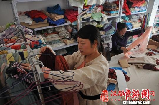 罗春林在工作室内整理布料。　武俊杰　摄