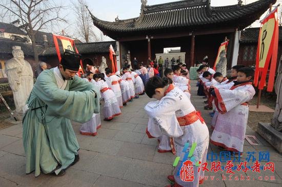 图为: 2017年1月16日，着汉服的孩子们进入大成殿后，面对孔子塑像，在老师的指导下，学礼仪。